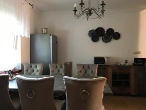 a living room with chairs and a table and a chandelier at Eden Apartman in Algyő