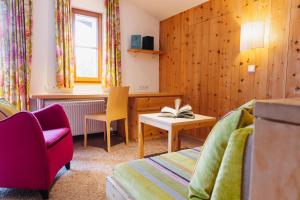 a room with a desk and a couch and a table at Hotel Aurora in Lech am Arlberg