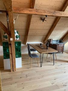 a wooden table and chair in a room with wooden ceilings at Ferienhaus Bäckerstadl Altmünster in Altmünster