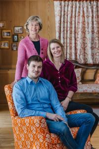 two women and a man sitting on a couch at Hotel Aurora in Lech am Arlberg