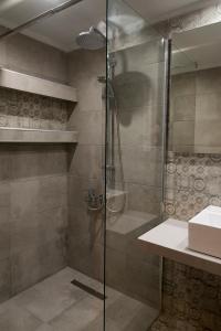 een douche met een glazen deur in de badkamer bij Stalis Hotel in Stalida
