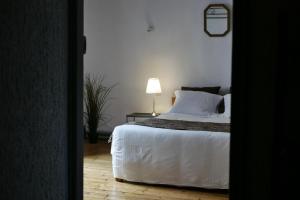 a bedroom with a bed and a lamp on a table at Les Oiseaux de Passage in Saint-Gaultier