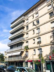 Un edificio alto con coches aparcados delante. en A casa di Brenda, en Chiavari