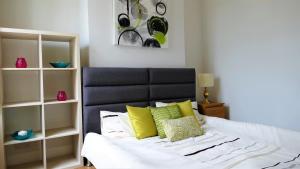 een slaapkamer met een bed met gele en witte kussens bij Beautifully renovated 2 Bed flat - Close to beach in Southend-on-Sea