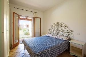 1 dormitorio con 1 cama con edredón azul en Residence Zodiaco, en Santa Teresa Gallura