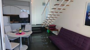 a living room with a purple couch and a table at Apartmani Antonieta in Veli Lošinj