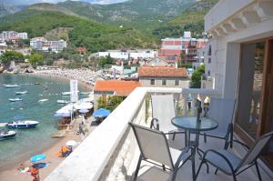balkon ze stołem i krzesłami oraz widokiem na plażę w obiekcie Andaluni Beach Apartments w mieście Pržno