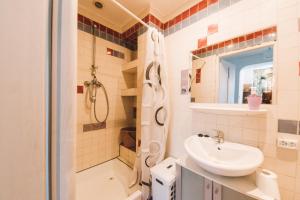 a white bathroom with a sink and a shower at Giżycko Studio Apartament in Giżycko