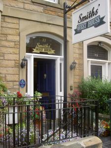 un hostal con un cartel delante de una puerta en Smiths Guest House en Edimburgo