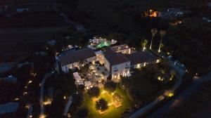 an aerial view of a mansion at night with lights at Donna Carmela Resort & Lodges in Riposto