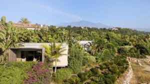 a house on a hill with trees and plants at Donna Carmela Resort & Lodges in Riposto