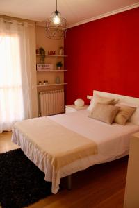 Entrena的住宿－Ático en el centro con terraza y barbacoa，一间卧室设有一张红色墙壁的大床