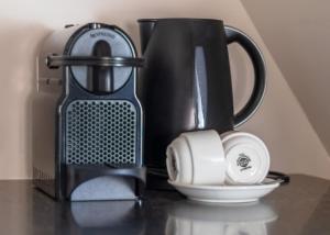 Abbey Abcoude في أبكود: آلة صنع القهوة السوداء وكوب على منضدة