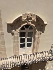 a window on the side of a building at Archè in Siracusa