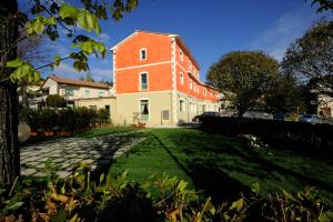 a large brick building with a grass yard at Hotel Dei Conti in Castelnuovo di Val di Cecina