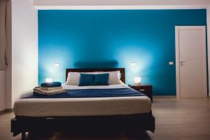a bedroom with a blue wall and a bed at Oasis in Acitrezza