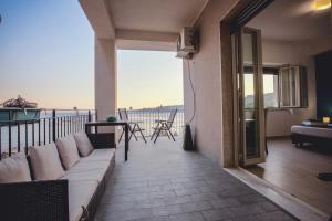 a couch on a balcony with a view of the ocean at Oasis in Acitrezza