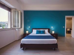 a bedroom with a blue wall and a bed at Oasis in Acitrezza