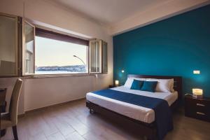 a bedroom with a large bed with a blue wall at Oasis in Acitrezza