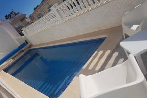 basen obok białego krzesła i stołu w obiekcie Pretty villa with private pool w mieście Los Alcázares