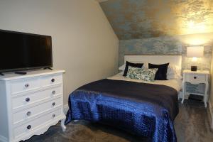 a bedroom with a bed and a flat screen tv at Kirkgate House in Knaresborough