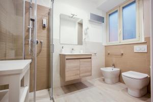 a bathroom with a toilet and a sink and a shower at Oasis in Acitrezza
