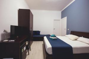 a bedroom with a bed and a desk and a television at Oasis in Acitrezza