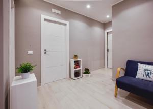 a living room with a white door and a blue couch at Oasis in Acitrezza