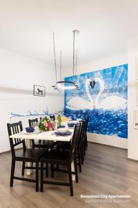 a dining room table with chairs and a painting of swans at Rovaniemi City Apartments in Rovaniemi