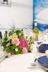 - une table avec un bouquet de fleurs et un verre de vin dans l'établissement Rovaniemi City Apartments, à Rovaniemi