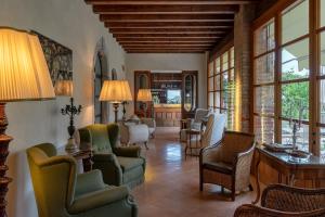 a living room with chairs and tables and windows at Villa Arcadio in Salò