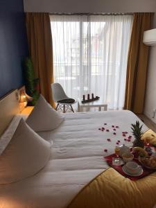 - un grand lit blanc avec un plateau de nourriture dans l'établissement Hotel Panorama, à Grasse