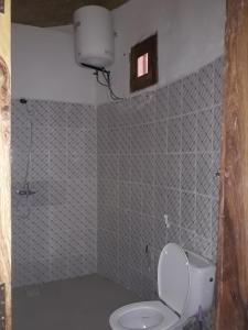 a small bathroom with a toilet and a window at Hotelgandiol - Saint-Louis in Saint-Louis