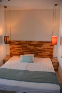 a bedroom with a large bed with two lights at Hotel Panorama in Grasse