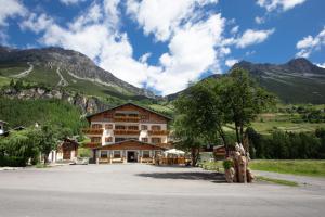 a large building in front of a mountain at Hotel Cima Piazzi in Valdidentro