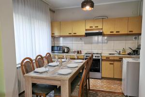 a kitchen with a wooden table with chairs and a kitchen with at Apartman Škudar in Bjelovar