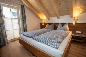 1 dormitorio con 1 cama grande y ventana grande en Zweimäderlhaus en Bad Mitterndorf