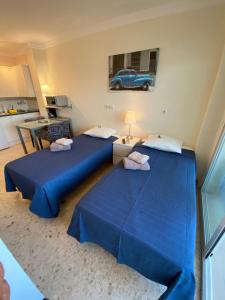 two blue beds in a room with a car on the wall at stella maris 1504 in Fuengirola