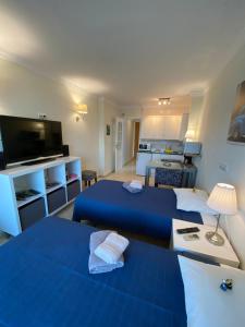 a living room with two blue beds and a kitchen at stella maris 1504 in Fuengirola