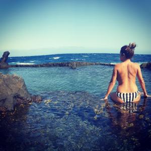 una mujer en traje de baño sentada en el océano en Rinconcito El Tablado en Güimar