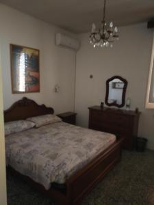 una camera con letto, specchio e lampadario a braccio di La casa di Alex a Matino
