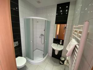 a bathroom with a shower and a toilet and a sink at Hotel Tequila in Międzyrzecz