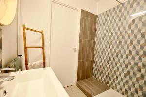 a bathroom with a shower and a white sink at Studio Royal de la Plage in Deauville +4 photos