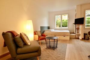 a living room with a couch and a bed at Studio Royal de la Plage in Deauville