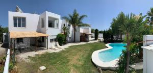 a villa with a swimming pool in front of a house at Panorama Village in Barbate