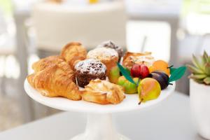 a plate of pastries and fruit on a table at Donna Carmela Resort & Lodges in Riposto