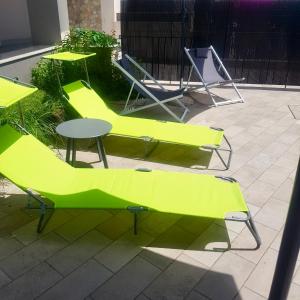 a group of green chairs and tables on a patio at Oasis in Acitrezza