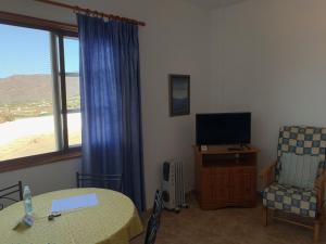 Pokój ze stołem, krzesłem i telewizorem w obiekcie Casitas Rosheli w mieście Los Llanos de Aridane