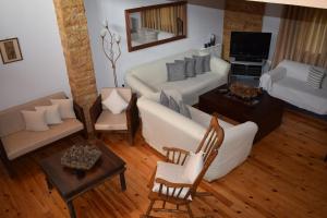 ein Wohnzimmer mit einem weißen Sofa und einem TV in der Unterkunft Family Villa Kalypso in Oreoi