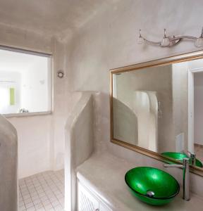baño con lavabo verde y espejo en Aelia by Eltheon, en Imerovigli